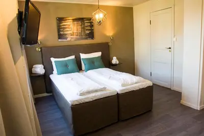 a bedroom with a large bed with blue pillows at Lillehammer Turistsenter Budget Hotel in Lillehammer