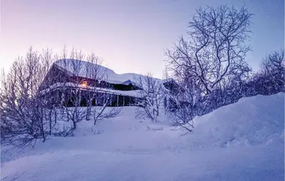 a building covered in snow with trees in front of it at Beautiful Home In Vøringsfoss With Wifi in Maurset