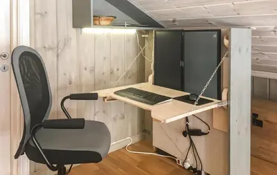 a laptop computer sitting on a desk with a chair at Nice Home In Lillehammer With Sauna in Lillehammer