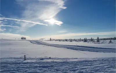 a snow covered field with the sun in the sky at Sjusjøen Setergrend 4724 C in Sjusjøen