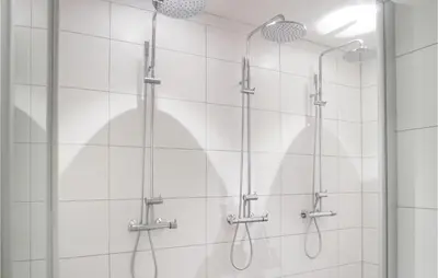 a shower with four shower heads on a wall at Lovely Home In Sjusjøen With Sauna in Sjusjøen