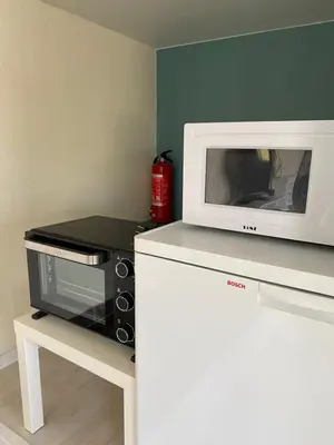 a microwave sitting on top of a counter with a toaster oven at 1-rom Apartment Sommer - Frøya in Sætra
