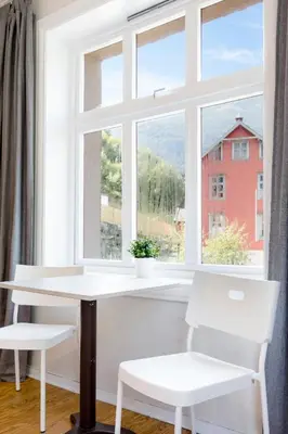 a white table and two chairs in front of a window at Slottet Apartments in Tysso