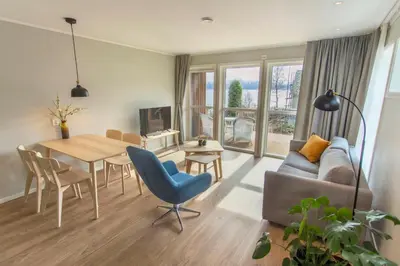 a living room with a couch and a table and chairs at Lavik Fjord Hotel & Apartments in Lavik