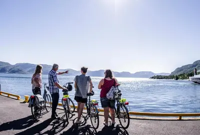 a group of people standing with their bikes by the water at Lavik Fjord Hotel & Apartments in Lavik