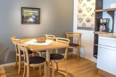 a kitchen with a wooden table and chairs at Geilolia Ferieleiligheter in Geilo