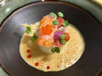 a plate of food with a piece of fish on top at Angvik Gamle Handelssted - by Classic Norway Hotels in Angvik