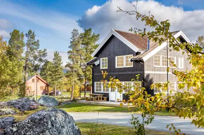 a black house with a gambrel roof at Geilolia Hyttetun in Geilo