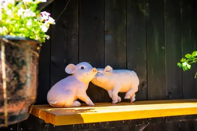 two pig statues sitting on a table next to a vase at Ullensvang Gjesteheim in Lofthus