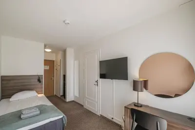 a hotel room with a bed and a mirror at Hardangerfjord Hotel in Øystese