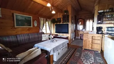 a living room with a table and a tv in a cabin at Suigard Smia in Sauland