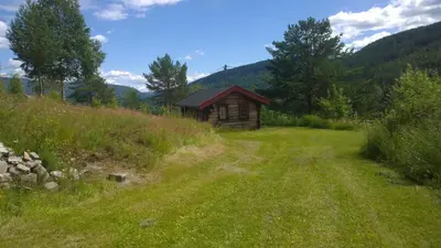 a small cabin in the middle of a grassy field at Suigard Smia in Sauland