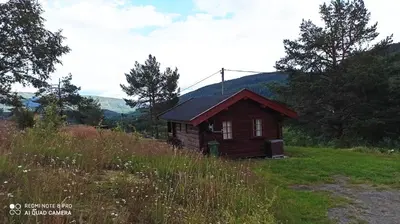 a small wooden cabin in a field of grass at Suigard Smia in Sauland