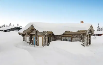 a log cabin covered in snow at Amazing Home In Sjusjøen With Sauna in Sjusjøen
