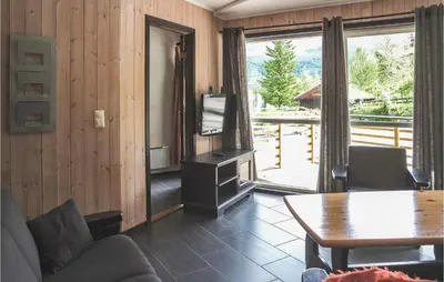 a living room with a couch and a table and a television at Cozy Apartment In Hemsedal With Sauna in Hemsedal