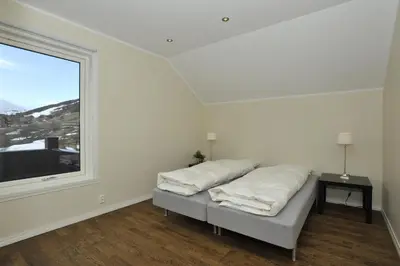 a white room with a bed and a window at Geilo Gaarden in Geilo
