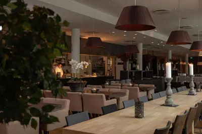 a restaurant with a long table and chairs and candles at Quality Hotel Skifer in Oppdal
