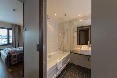 a bathroom with a tub and a sink and a shower at Quality Hotel Skifer in Oppdal