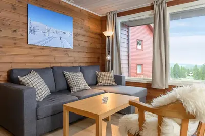 a living room with a blue couch and a table at Lillehammer Fjellstue og Hytteutleie in Nordseter