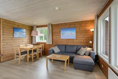a living room with a couch and a table at Lillehammer Fjellstue og Hytteutleie in Nordseter