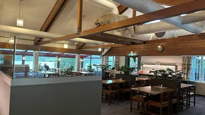 a dining room with tables and chairs and windows at Kroderen Kro & motel AS in Hamremoen