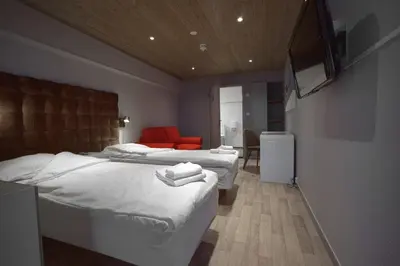 a bedroom with two beds and a red couch at Kroderen Kro & motel AS in Hamremoen