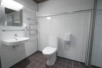 a white bathroom with a toilet and a sink at Kroderen Kro & motel AS in Hamremoen