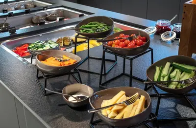 a kitchen counter with bowls of vegetables on a counter at Thon Hotel Trondheim in Trondheim