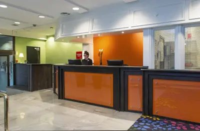 a woman sitting at a counter in a hospital lobby at Thon Hotel Trondheim in Trondheim