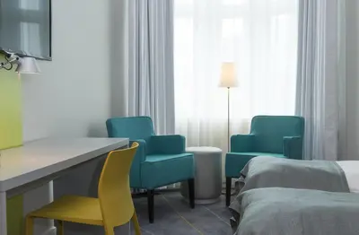 a hotel room with blue chairs and a bed at Thon Hotel Trondheim in Trondheim
