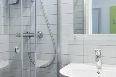 a bathroom with a shower and a white sink at Thon Hotel Trondheim in Trondheim
