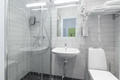 a white bathroom with a sink and a mirror at Thon Hotel Trondheim in Trondheim