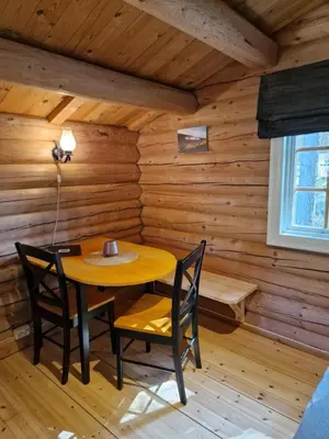 a dining room with a table and chairs in a log cabin at Weistad in Heidal