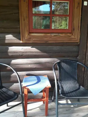 two chairs and a table on the porch of a cabin at Weistad in Heidal