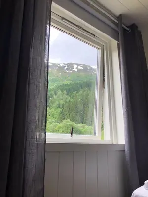 a window in a bathroom with a view of a mountain at Tunold Gård - Gamle huset in Mindresunde