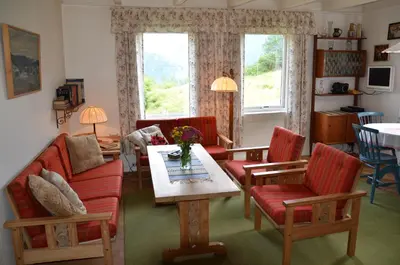 a living room with a couch and a table and chairs at Tunold Gård - Gamle huset in Mindresunde