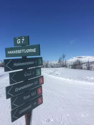 a street sign in the snow next to a road at Ustedalen Lodge, Appartement 1 in Geilo