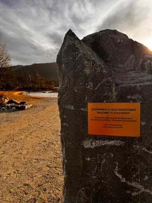 a rock with a sign on it on a beach at Ustedalen Lodge, Appartement 1 in Geilo