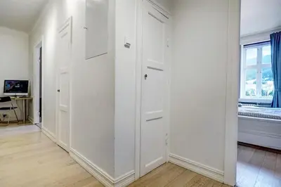 a white room with white doors and a window at Apartment with Beautiful View to Bryggen in Bergen