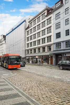a bus is parked in front of a building at Apartment with Beautiful View to Bryggen in Bergen