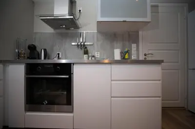 a kitchen with white cabinets and a stove at Apartment at Ranheim in Trondheim