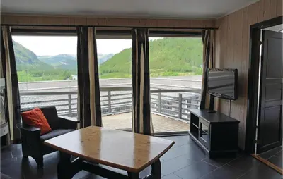 a room with a table and a tv and a balcony at Pet Friendly Apartment In Hemsedal in Hemsedal