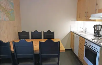 a small kitchen with a wooden table and chairs at Pet Friendly Apartment In Hemsedal in Hemsedal