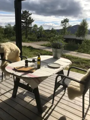 a table and two chairs on a wooden deck at Remestøylflotti Hyttegrend in Hovden