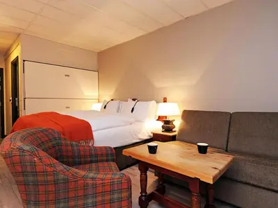a hotel room with a bed and a couch at Hunderfossen Hotel & Resort in Hafjell