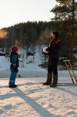 a man and a child standing in the snow at Hunderfossen Hotel & Resort in Hafjell