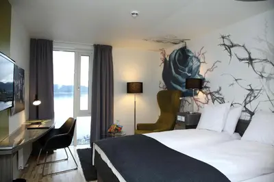 a hotel room with a bed and a desk and a television at Scandic Rock City in Namsos