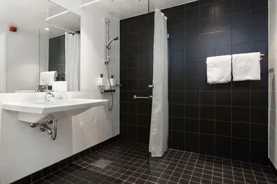 a bathroom with a sink and a shower at Scandic Rock City in Namsos