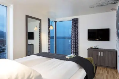 a bedroom with a large bed with a large window at Scandic Rock City in Namsos