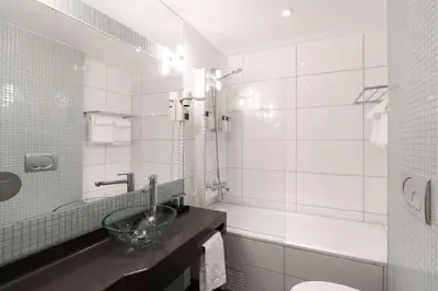 a bathroom with a sink and a toilet and a tub at Scandic Byparken in Bergen